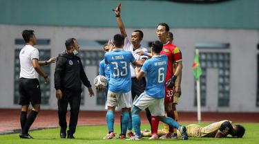 Wasit Marjukih memberikan kartu merah ke pelatih Sulut United Ricky Nelson (dua kiri) usai merebut paksa bola yang akan dilempar ke dalam oleh pemain Dewa United. (Bola.com/Bagaskara Lazuardi)