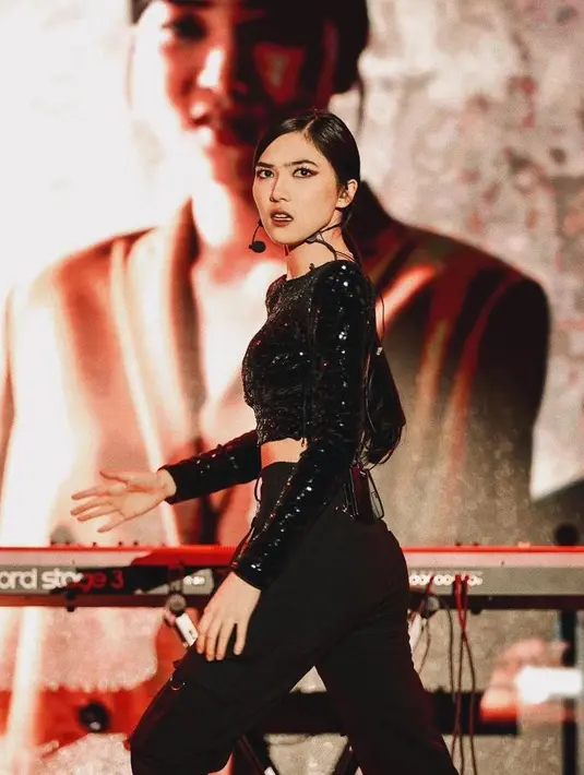 Begini tampilan Isyana saat di panggung. Pelantun “Kau Adalah” itu terlihat memesona kenakan sequined crop top dengan high waist pants. Tak lupa ciri khas pulasan makeup dengan lipstik gelap. (Instagram/isyanasarasvati).
