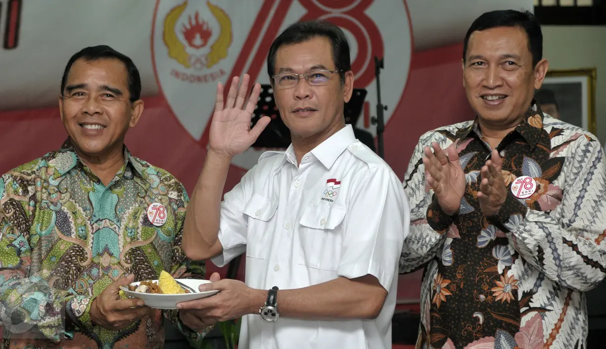 Ketua Umum KONI Pusat Mayjen Tono Suratman (kiri) memberikan potongan tumpeng kepada Wakil Ketum KOI Muddai Madang di Gedung Serba Guna GBK, Jakarta, Rabu (19/10). KONI menggelar syukuran dalam rangka peringatan HUT yang ke-78. (Liputan6.com/Yoppy Renato)