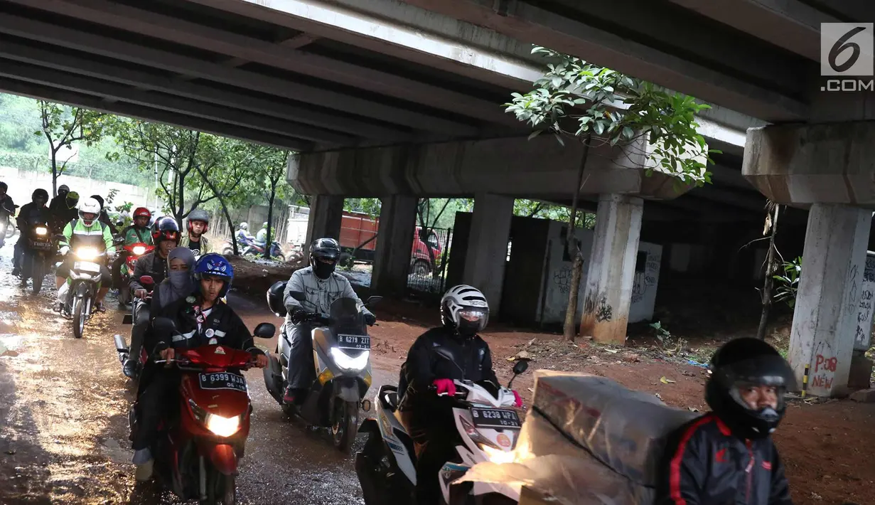 Pengendara motor melintasi jalan setapak di kolong tol di kawasan Lebak Bulus, Jakarta, Selasa (13/2). Untuk menghindari macet sebagian pengendara memanfaatkan jalan setapak tersebut untuk memersingkat waktu tempuh. (Liputan6.com/Immanuel Antonius)