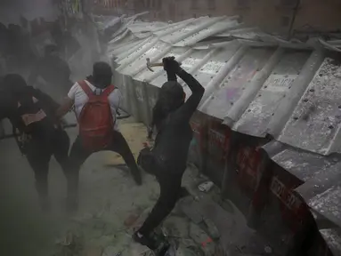 Demonstran menyerang barikade yang melindungi Istana Nasional selama pawai untuk memperingati Hari Perempuan Internasional dan memprotes kekerasan gender di Mexico City, Meksiko, Senin (8/3/2021). Hari Perempuan Internasional diperingati setiap tanggal 8 Maret. (AP Photo/Rebecca Blackwell)