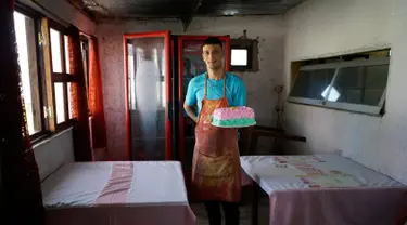 Narapidana Nelson Avantti memegang kue di toko rotinya di Penjara Punta de Rieles, Montevideo, Uruguay, 18 Mei 2019. Uang untuk memulai bisnis seperti milik Avantti berasal dari keluarga narapidana atau bank yang sebagian besar dikelola oleh narapidana sendiri. (AP Photo/Matilde Campodonico)