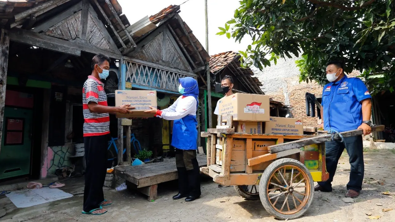 Penyerahan bantuan paket bahan pokok kepada warga kurang mampu