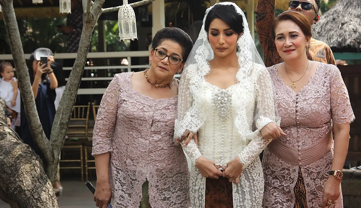 Bintang film Air Terjun Pengantin itu tampil cantik dengan kostum putih. Sama dengan pengantin pria yang terlebih dulu berada di pendopo untuk melaksanakan ijab kabul. (Bambang E. Ros/Bintang.com)