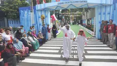 Masyarakat Perum Depok Maharaja Blok M1 Cluster Cemara, Rangkapan Jaya menggelar peragaan busana atau fashion show unik menjelang pesta pembukaan Piala Dunia 2022 pada Minggu (20/11/2022). (Bola.com/Merdeka.com/Arie Basuki)