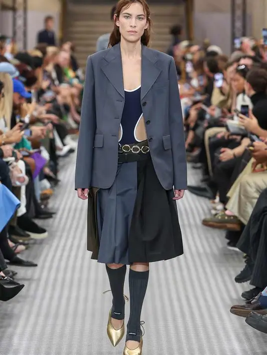 Cara Delevingne  membuat penampilan megahnya di atas catwalk dengan setelan kulit dua potong yang dipadukan dengan kardigan merah beritsleting. Bintang 32 tahun itu kemudian menyempurnakan penampilannya dengan sepasang sandal cokelat dan riasan mata smokey yang membuat mata birunya yang terkenal itu menonjol.