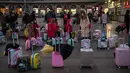 Calon penumpang menunggu jadwal keberangkatan kereta di luar stasiun Beijing, Selasa (29/1). Jutaan orang telah meninggalkan kota-kota besar China menuju kampung halaman, guna merayakan Imlek pada awal Februari mendatang. (Nicolas ASFOURI/AFP)