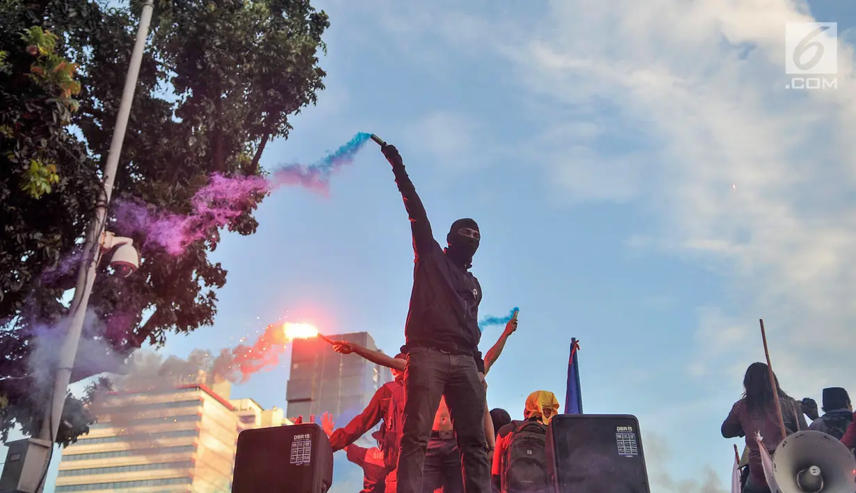 Sejumlah buruh menyalakan bom asap saat menutup aksi Hari Buruh Internasional di Jalan Medan Merdeka Barat, Jakarta, Rabu (5/1/2019). Aksi May Day 2019 di Jakarta ditutup oleh buruh dengan menyalakan kembang api sebagai simbol berjalannya demo dengan damai. (merdeka.com/Iqbal S Nugroho)