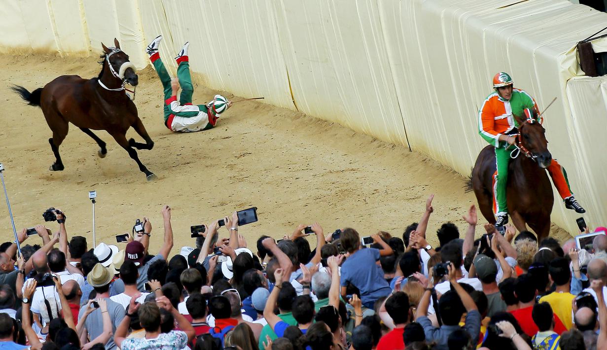 Seorang joki terjatuh saat beraksi dalam lomba pacuan kuda tahunan Palio di Siena, Italia. (Reuters/Fabio Muzzi)