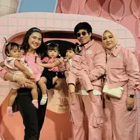 Felicya Angelista tampil mengenakan atasan crop top pink dipadukan celana hitamnya. Ia membawa kedua anaknya yang juga mengenakan baju pink. [@felicyangelista_]