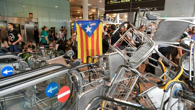 Para demonstran Catalonia melakukan unjuk rasa di bandara sebagai salah satu bentuk perjuangan akan kemerdekaan. (Source: AFP/ Lluis Gene)