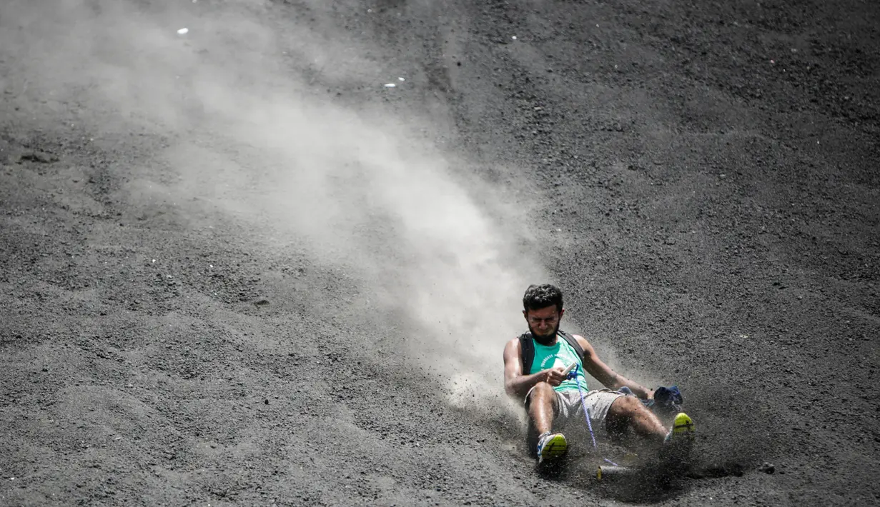 Ekspresi seorang wisatawan ketika bermain sandboarding atau berseluncur pasir menuruni gunung berapi Cerro Negro di Leon, Nikaragua, 24 September 2016. Gunung Cerro Negro salah satu gunung api yang masih aktif di Nikaragua. (INTI Ocon/AFP)
