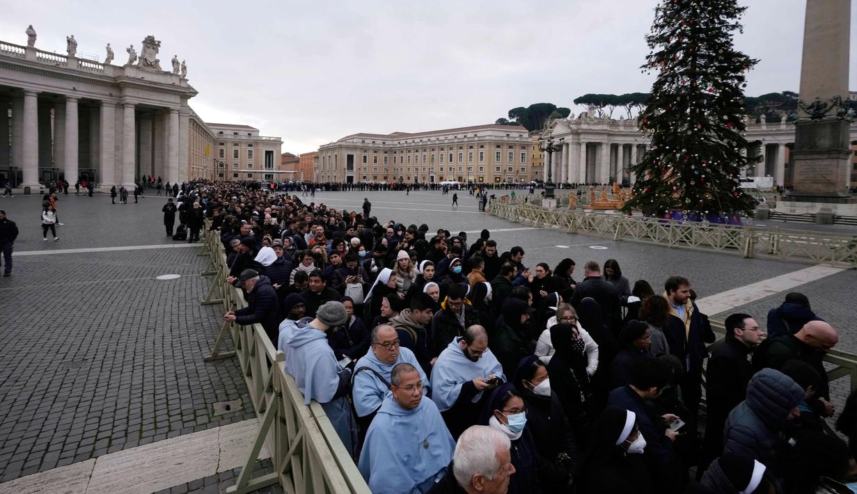 Orang-orang mengantre untuk memasuki Basilika Santo Petrus tempat mendiang Paus Emeritus Benediktus XVI disemayamkan di Vatikan, Senin (2/1/2023). Benediktus XVI, teolog Jerman yang akan dikenang sebagai paus pertama dalam 600 tahun yang mengundurkan diri, telah meninggal pada 31 Desember 2022 di usia 95 tahun. (AP Photo/Alessandra Tarantino)