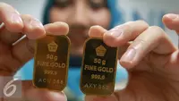 Seorang teller menunjukan emas batangan di Jakarta, Selasa (15/11). Harga emas batangan atau Logam Mulia milik PT Aneka Tambang Tbk (Antam) hari ini dibuka turun Rp 2.000/gram. (Liputan6.com/Angga Yuniar)