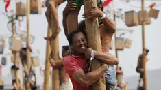 Seorang peserta berusaha menahan rekannya saat mengikuti lomba panjat pinang selama perayaan HUT ke-74 RI di Pantai Ancol, Jakarta, Sabtu (17/8/2019). Indonesia merayakan kemerdekaan yang ke-74 dari pemerintahan kolonial Belanda. (AP Photo/Tatan Syuflana)