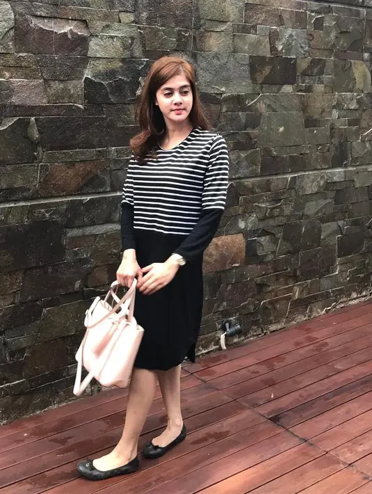Tak berlebihan, kali ini Biby hanya memakai dress hitam bermotif garis-garis dengan ballerina shoes hitamnya juga. Tas jinjing berwarna baby pink membuat penampilannya makin terlihat sederhana. (Instagram/Bibyalraen13)