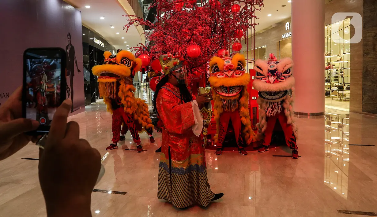 Pengunjung mengabadikan Kelompok Barongsai yang beraksi untuk merayakan Tahun Baru Imlek 2572 di Senayan City mall, Jakarta, Jumat (12/2/2021). Selain menghibur, atraksi barongsai juga dipercaya masyarakat Tionghoa mampu mengusir roh-roh jahat yang mengganggu. (Liputan6.com/Johan Tallo)