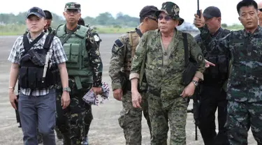 Presiden Filipina, Rodrigo Duterte bersiap naik helikopter untuk melakukan kunjungan ke medan pertempuran di Marawi, Kamis (20/7). Kunjungan dilakukan ketika pasukan masih terlibat pertarungan dengan kelompok Maute yang berafiliasi dengan ISIS. (AP Photo)