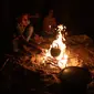 Warga Palestina duduk mengitari api unggun di luar rumah saat pemadaman listrik terjadi di Kota Khan Younis, Jalur Gaza selatan, pada 18 Agustus 2020. Satu-satunya pembangkit listrik di Jalur Gaza telah sepenuhnya berhenti beroperasi akibat kehabisan bahan bakar. (Xinhua/Yasser Qudih)