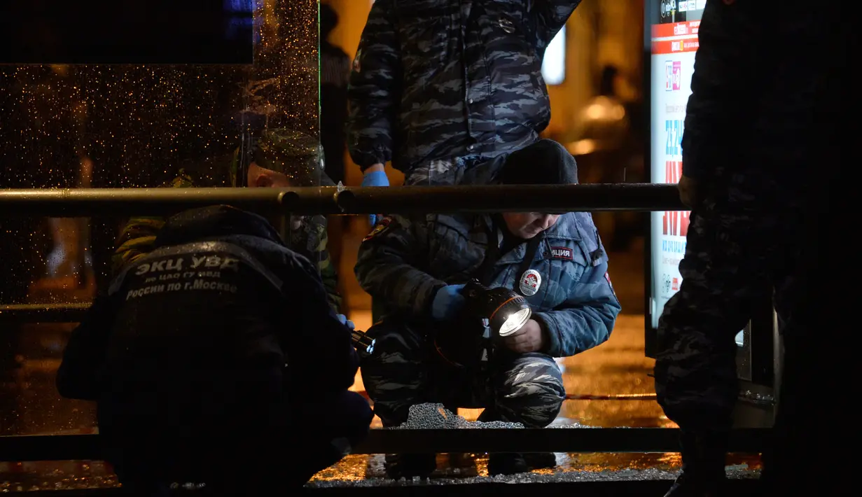 Petugas menyelidiki sebuah halte bus yang rusak akibat terkena ledakan di Moskow, Rusia, Senin (7/12). Tiga orang luka terkena pecahan kaca. Bahan peledak diperkirakan dilemparkan dari mobil atau bangunan perumahan di dekatnya. (AFP/NATALIA Kolesnikova)