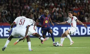Pemain Barcelona, Lamine Yamal (tengah), berlari dengan bola dan diganggu bek Paris Saint-Germain, Nuno Mendes (dua dari kiri), pada laga Liga Champions di Estadi Olimpic Lluis Companys, Kamis (2/10/2025) dini hari WIB. (Lluis Gene/AFP)