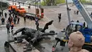 <p>Pekerja membongkar monumen era Soviet untuk persahabatan antara Rusia dan Ukraina terlihat selama pembongkarannya, di tengah invasi Moskow di Kiev tengah, Ukraina, Selasa (26/4/2022). Salah satu perancang patung itu mengatakan kondisi perang antara Rusia-Ukraina jadi alasan kenapa patung itu akhirnya dibongkar. (Genya SAVILOV / AFP)</p>