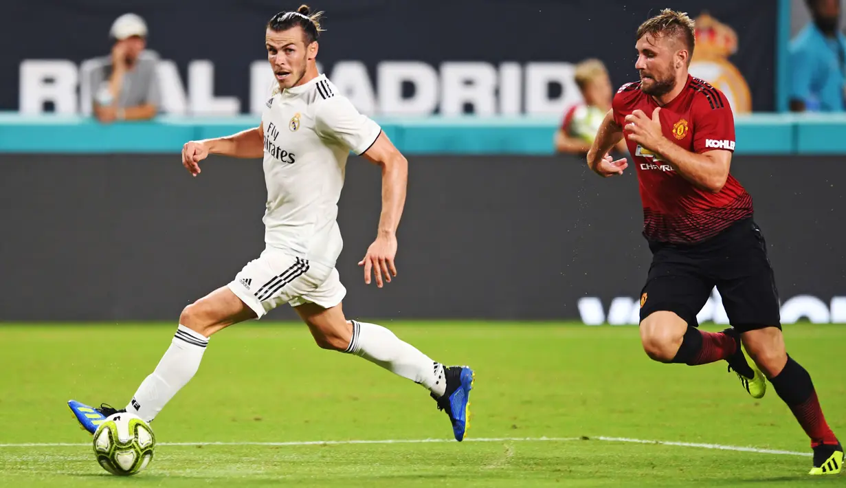 Gelandang Real Madrid, Gareth Bale menggiring bola dari kejaran bek Manchester United, Luke Shaw saat bertanding pada International Champions Cup di Miami Gardens, Fla (31/7). MU menang tipis 2-1 atas Madrid. (Jim Rassol/South Florida Sun-Sentinel via AP)
