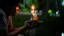 Seorang wanita berdoa sebelum menghayutkan 'krathong' untuk merayakan festival Loy Krathong di sebuah danau di Bangkok, Kamis (22/11). Loy Krathong dirayakan setiap tahun di seluruh Thailand sebagai penghormatan kepada dewi air. (Jewel SAMAD/AFP)