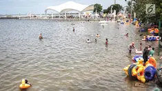 Sejumlah pengunjung bermain air di Beach Pool Ancol, Jakarta, Selasa (25/12). Pasangnya air laut dan cuaca buruk mengakibatkan pantai Ancol sepi pengunjung saat libur Natal 2018. (Liputan6.com/Faizal Fanani)