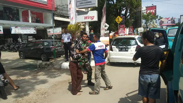 Kopda Emanuel, berusaha melerai sejumlah warga yang hendak memukul pelajar yang berusaha merusak angkot.(Liputan6.com/Ahmad Akbar Fua)