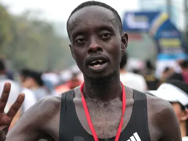 Pelari kenya Bernard Mwendia Muthoni usai menyelesaikan lari Full Marathon dalam Jakarta Marathon 2018 di GBK, Jakarta, Minggu (28/10). Bernard berhasil sampai finish kategori Full Marathon dalam catatan waktu 02:19:10. (Liputan6.com/Faizal Fanani)