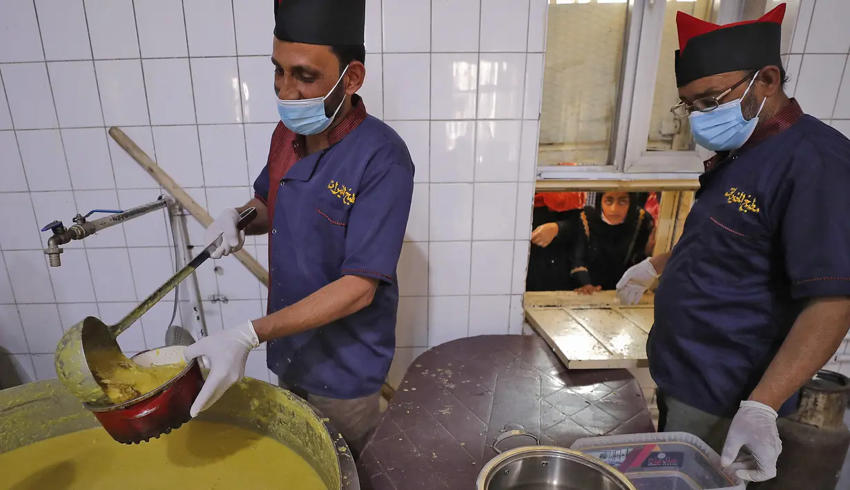 Para juru masak menyajikan makanan berbuka puasa kepada yang membutuhkan dari dapur di Masjid Muslim Sunni Abdel Kader al-Kilani di Baghdad, Irak, 19 April 2021. Kegiatan ini berlangsung selama bulan suci Ramadhan. (AHMAD AL-RUBAYE/AFP)