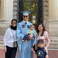 Di acara kelulusan, Randi Bachtiar terlihat Tasya mengenakan dress satin warna pink. Sedangkan ibu mertua mengenakan atasan putih lengan panjang dipadukan celana hitam serasi dengan kerudungnya, sambil membawa handbag coklatnya Hermes. [@randibachtiar]