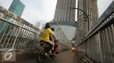 Pengendara sepeda motor melintas di atas Jembatan Penyeberangan Orang (JPO) di kawasan Grogol, Jakarta, Rabu (4/5). JPO yang seharusnya diperuntukkan bagi pejalan kaki itu kini sering dimanfaatkan pengendara motor. (Liputan6.com/Gempur M Surya)