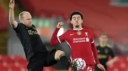 Gelandang Ajax Amsterdam, Davy Klaassen berebut bola dengan gelandang Liverpool, Curtis Jones pada matchday kelima Grup D Liga Champions di Anfield, Selasa (1/12/2020). Curtis Jones mencetak gol satu-satunya yang membawa Liverpool melaju ke babak 16 besar. (Michael Regan/Pool via AP)