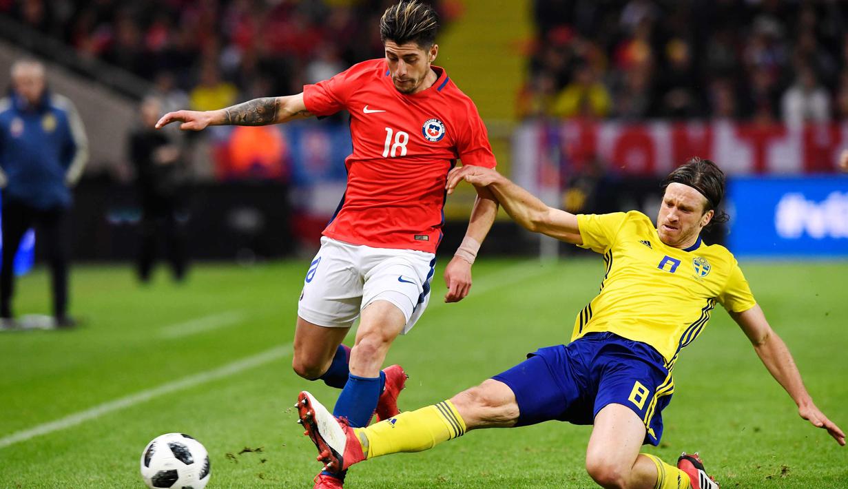 Bek Chile, Angelo Sagal (kiri) berusaha membawa bola dari kawalan gelandang Swedia, Gustav Svensson saat bertanding pada pertandingan persahabatan internasional Friends di Arena, Stockholm, (24/3). Chile menang 2-1 atas Swedia. (Anders Wiklund/TT via AP)