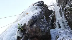 Aksi seorang perempuan memanjat dinding es buatan di desa Vir, Republik Ceko, Minggu (14/2/2021). Ketika suhu turun di Republik Ceko, pemanjat tebing memanfaatkan kondisi beku dengan mengubah permukaan batu menjadi dinding es setinggi 20 meter untuk pendaki. (AP Photo/Petr David Josek)
