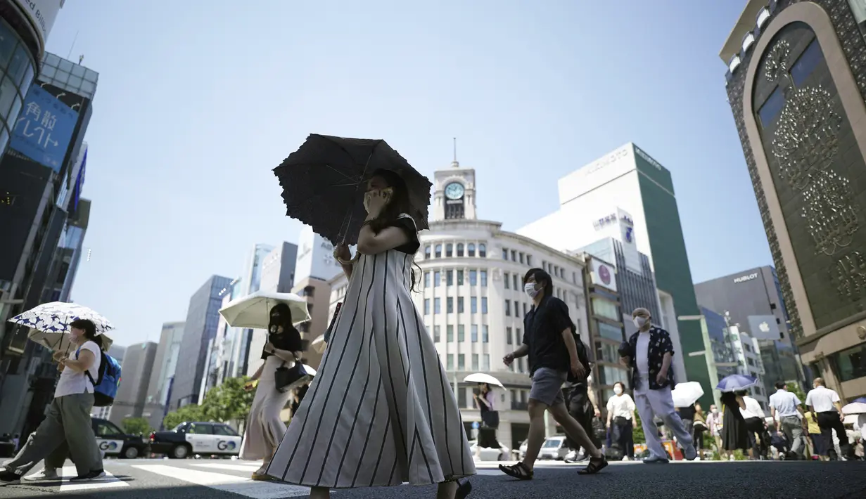 <p>Orang-orang berjalan di atas penyeberangan pejalan kaki di bawah terik matahari di Tokyo, Selasa (28/6/2022). Pemerintah Jepang mengeluarkan peringatan untuk kemungkinan pemadaman listrik di wilayah Tokyo pada hari Senin (27/6), meminta kantor dan penduduk untuk menghemat energi karena wilayah ibu kota dilanda panas terik. (AP Photo/Eugene Hoshiko)</p>