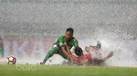 Pemian PS TNI, Ahmad Nufian Dani (kiri) berebut bola dengan pemain Persiba Balikpapan saat guyuran hujan pada laga pekan keempat Liga 1 2017 di Stadion Pakansari, Bogor, Jumat (5/5/2017). (Bola.com/Nicklas Hanoatubun)