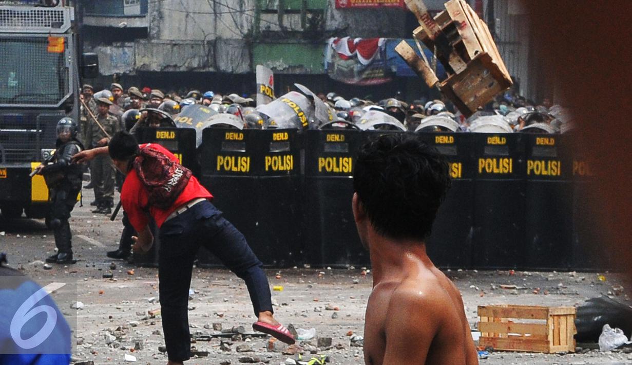 Warga Kampung Pulo menyerang Petugas saat penggusuran Kampung Pulo, Jakarta, Kamis (20/8/2015). Penggusuran pemukiman Kampung Pulo dilakukan oleh 2.200 personel gabungan untuk normalisasi Sungai Ciliwung. (Liputan6.com/Herman Zakharia)