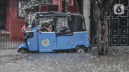 Sebuah bajaj saat terjebak banjir yang merendam Jalan Abdullah Syafei, Tebet, Jakarta, Kamis (18/2/2021). Banjir juga menyebabkan akses putar balik di kawasan dekat Stasiun Tebet itu terputus. (merdeka.com/Iqbal S Nugroho)