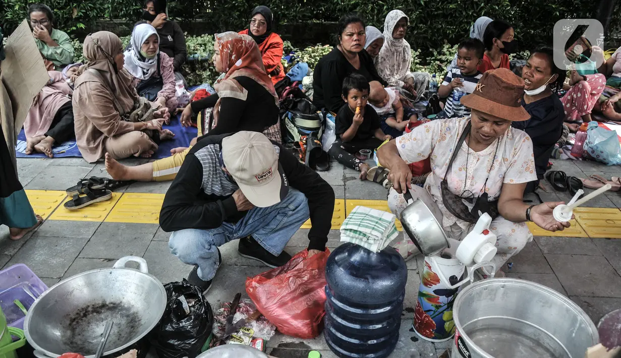 Warga memasak untuk makan bersama saat menggelar aksi di depan Balai Kota, Jakarta, Senin (5/12/2022). Warga Kampung Susun Bayam belum merasakan janji manis dari Jakarta Propertindo (Jakpro) dan Pemerintah Provinsi DKI Jakarta. Mulanya, mereka dijanjikan akan direlokasi di Kampung Susun Bayam setelah rumahnya digusur untuk pembangunan JIS, namun sampai saat ini warga masih terlantar. (merdeka.com/Iqbal S. Nugroho)