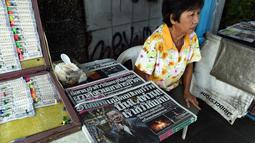 Penjual menunggu pembeli surat kabar dengan berita utama kecelakaan helikopter pemilik Leicester City Vichai Srivaddhanaprabha di Bangkok, Senin (29/10). Bos Leicester City tewas ketika helikopternya jatuh dan terbakar. (Lillian SUWANRUMPHA/AFP)
