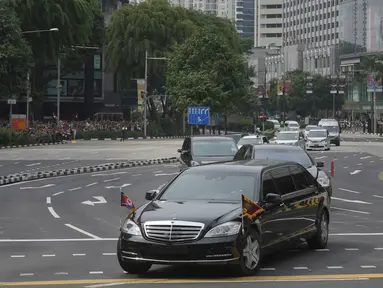 Iring-iringan mobil yang diyakini membawa pemimpin Korea Utara Kim Jong-un melewati Orchard Road menuju St Regis Hotel di Singapura, Minggu (10/6). Kedatangan Kim menjelang pertemuan bersejarah dengan Donald Trump pada Selasa mendatang. (AP/Joseph Nair)