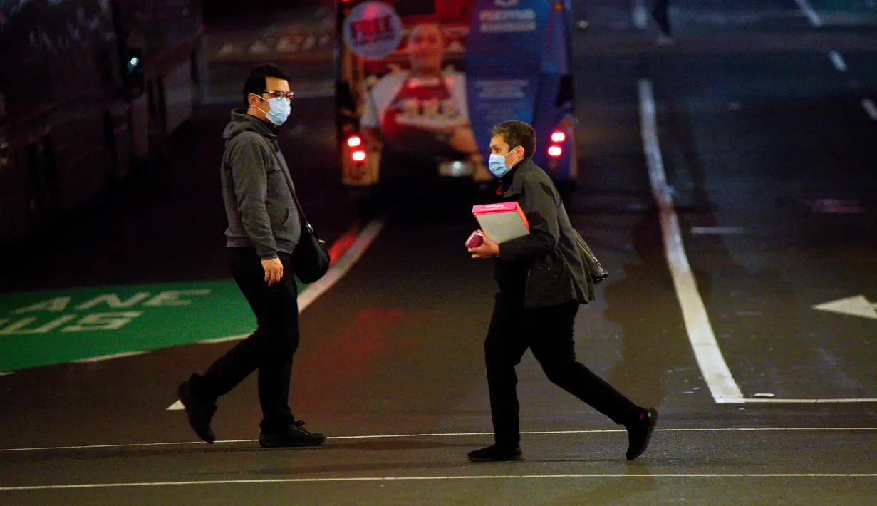 Dua orang yang mengenakan masker melintas di jalan Kota Auckland, Selandia Baru, Rabu (12/8/2020). Kota terbesar di Selandia Baru ini pada 12 Agustus 2020 kembali memberlakukan Siaga COVID-19 Level 3 selama tiga hari setelah empat kasus terkonfirmasi pada 11 Agustus 2020. (Xinhua/Li Qiaoqiao)