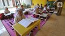 Murid kelas III SDN 02 Pondok Petir mengikuti kegiatan belajar mengajar di teras rumah salah satu siswa di Depok, Senin (31/08/2020). Sudah hampir dua minggu ini, mereka mengadakan pembelajaran secara tatap muka dengan guru yang berkeliling atas permintaan wali murid. (merdeka.com/Arie Basuki)