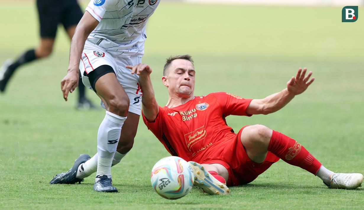 <p>Pemain Persija Jakarta,&nbsp;Maciej Jacek Gajos (kanan), berusaha menghalau bola dari kaki pemain Arema FC&nbsp;dalam pertandingan pekan kesembilan BRI Liga 1 2023/2024 yang berlangsung di Stadion Patriot Candra Bhaga, Bekasi, Minggu (20/9/2023). (Bola.com/M Iqbal Ichsan)</p>