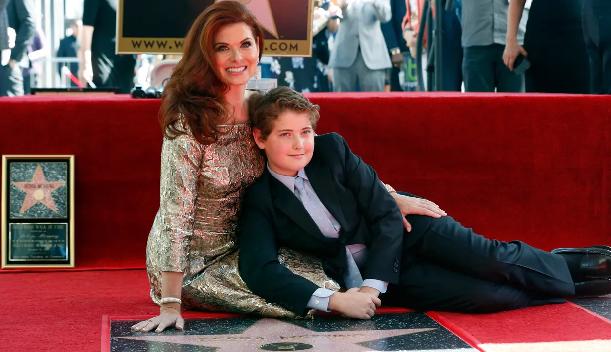 Akrtis asal Amerika Serikat, Debra Messing bersama sang putra  berpose di sebuah plakat bintang atas namanya pada upacara pengargaan di Hollywood Walk of Fame, Los Angeles, Jumat (6/10). (Photo by Willy Sanjuan/Invision/AP)