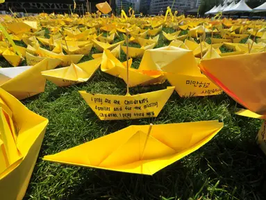 Pesan-pesan untuk mengenang korban feri Sewol ditulis dalam kertas kuning berbentuk kapal di Balai Kota Seoul, Rabu (7/5/14). (AFP PHOTO/JUNG YEON-JE)