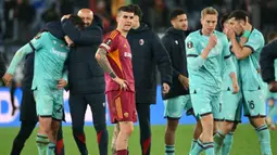 Duel harus memanjang ke fase extra time setelah kedua tim berbagi skor 3-3 pada waktu normal. Tampak dalam foto, ekspresi bek AS Roma, Gianluca Mancini (tengah) saat para pemain Bologna merayakan kemenangan setelah pertandingan leg kedua 16 besar Liga Europa 2025/2026 di Stadion Olimpico, Kamis (19/3/2026) waktu setempat atau Jumat 20 Maret 2026 dini hari WIB. (Alberto PIZZOLI/AFP)
